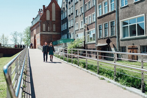 Happy guy and woman walking along the tourist streets of old Europe in the city of Gdansk