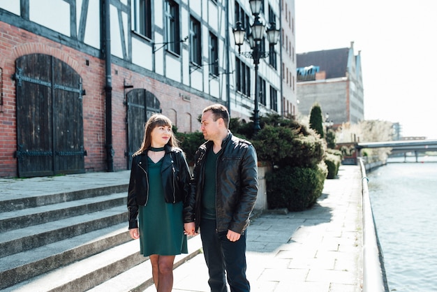 Happy guy and woman walking along the tourist streets of old Europe in the city of Gdansk