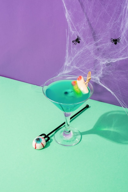 Happy Halloween concept. Scary colorful purple Halloween cocktails with party decorations on purple background