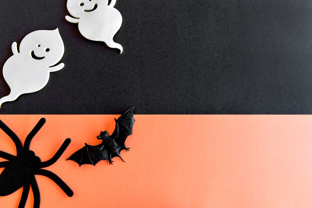 Happy Halloween decoration. Bats, spider and ghost on orange background.