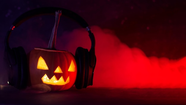 Happy Halloween glowing pumpkin lantern with headphones on dark red background Holiday background with copyspace banner