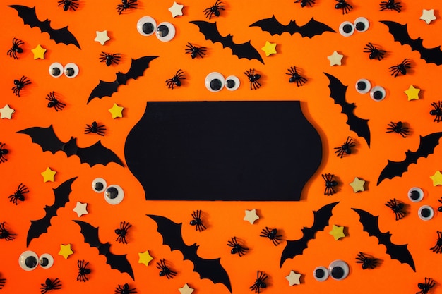 Happy Halloween greeting card with small decorative bats, spiders and puppet eyes.