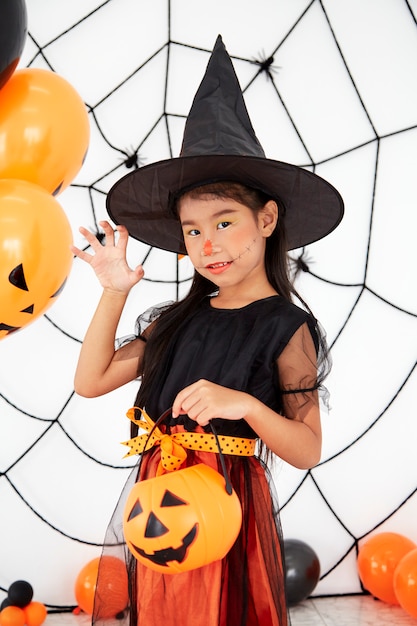 Happy Halloween little witch with a pumpkin