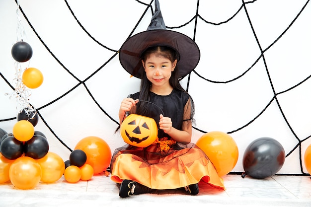 Happy Halloween little witch with a pumpkin