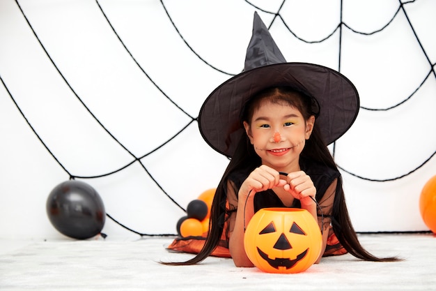 Happy Halloween little witch with a pumpkin