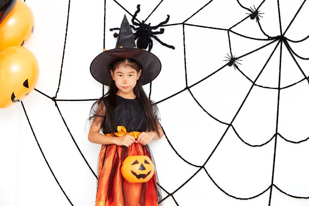 Happy Halloween little witch with a pumpkin