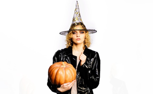 Happy halloween sexy girl with orange pumpkin serious woman in witch costume with jackolantern