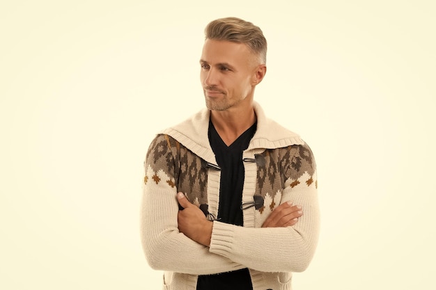 Happy handsome guy in cardigan look aside keeping arms crossed isolated on white confident