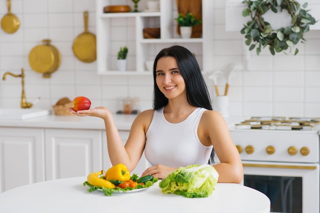 Happy healthy woman holds a peach fruit in the palm of her hand choosing healthy food