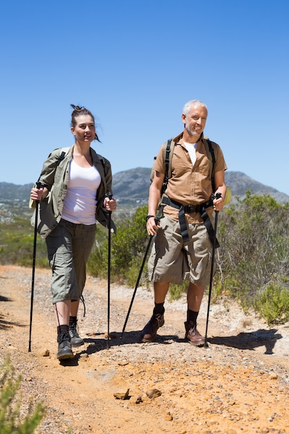 Happy hiking couple walking on mountain trail 