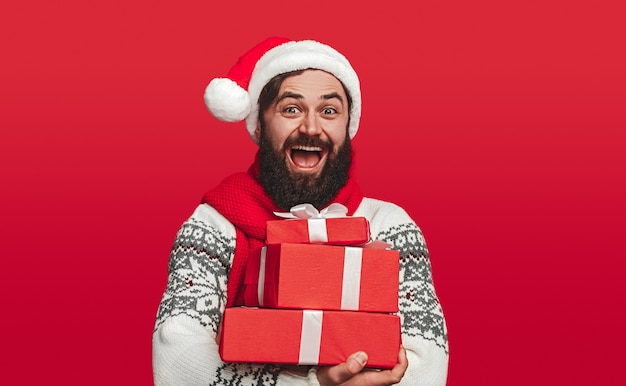 Happy hipster embracing bright wrapped Christmas gifts