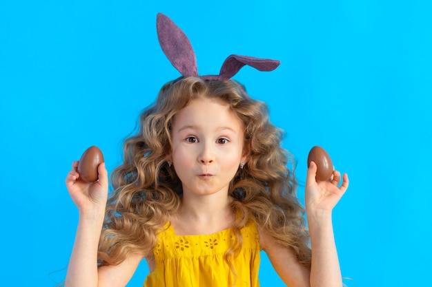 Happy holiday easter kids girl in rabbit hare bunny ears and chocolate eggs