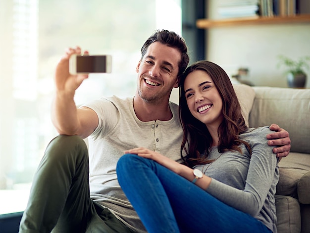 Happy at home with my love Shot of a happy young couple taking selfies together at home