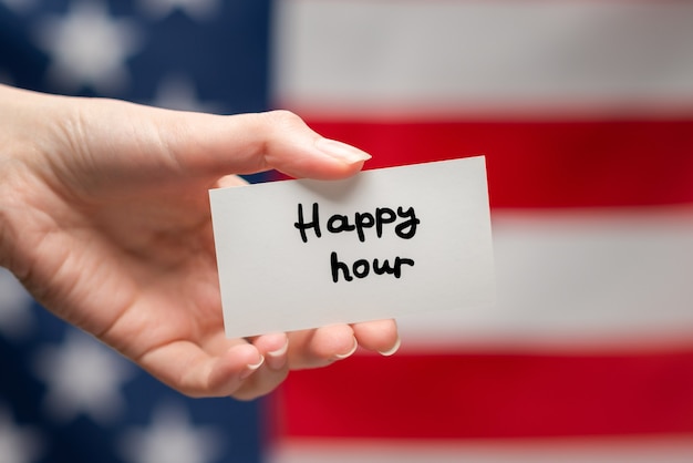 Happy hour text on a card. American flag background.