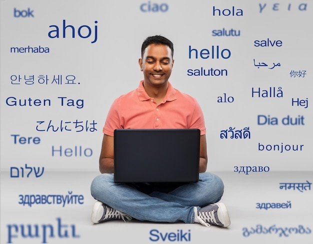 Photo happy indian man with laptop computer on floor