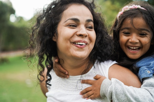 Happy indian mother having fun with her daughter outdoor  Soft focus on mom face