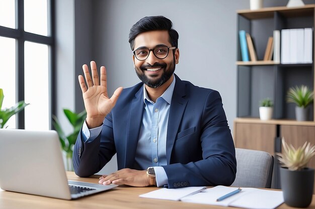 Happy indian professional business man teacher business coach or hr manager waving hand remote working by video call having hybrid office online meeting leading training or webinar elearning class