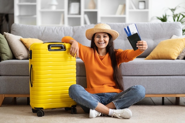 Happy indian woman going vacation showing flight tickets