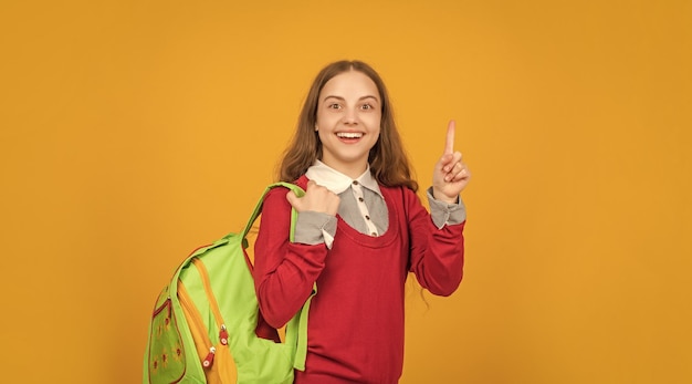 Happy inspired with idea teen girl with school backpack on yellow background school