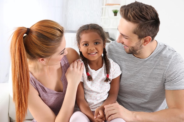 Happy interracial family sitting on sofa