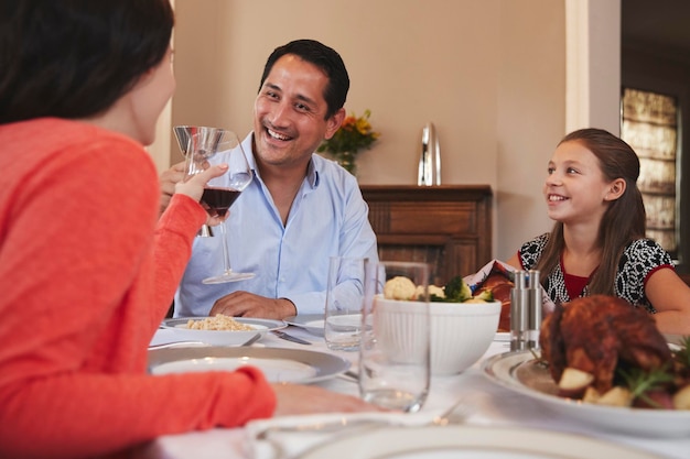 Happy Jewish family raising glasses before Shabbat meal