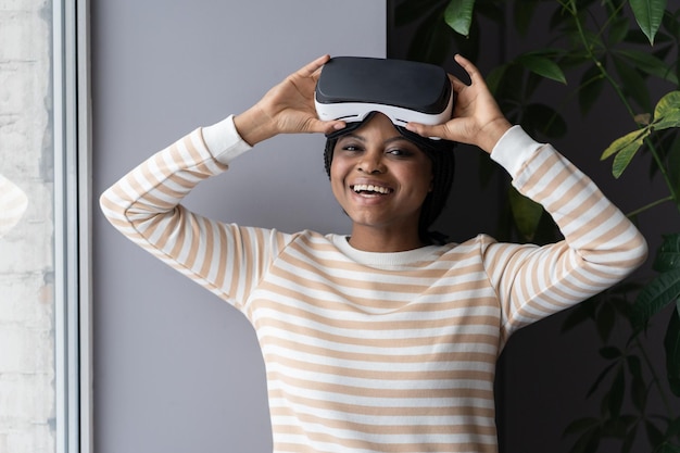 Happy joyful afro woman taking vr helmet off black female using virtual reality glasses at home