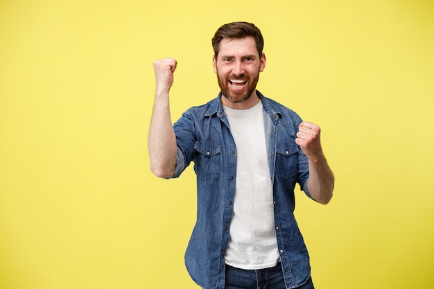 Happy joyful man doing winner gesture clenching fists