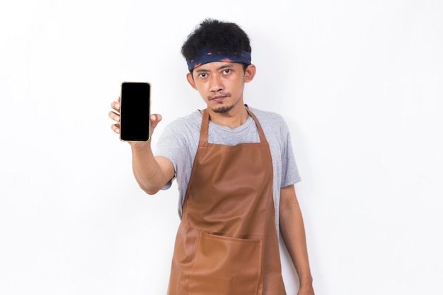 Happy joyful young asian man barista bartender demonstrating mobile cell phone on white background