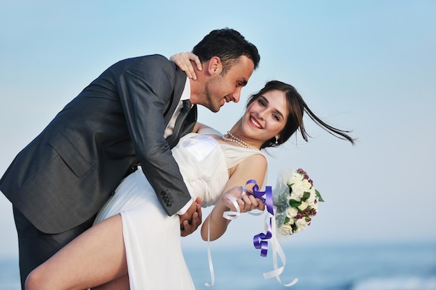 happy just married young couple celebrating and have fun at beautiful beach sunset