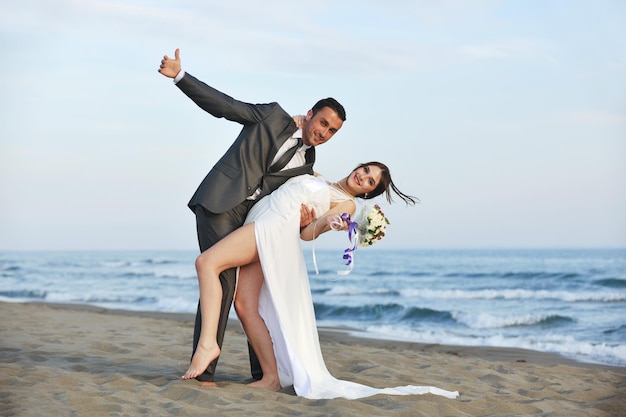 happy just married young couple celebrating and have fun at beautiful beach sunset