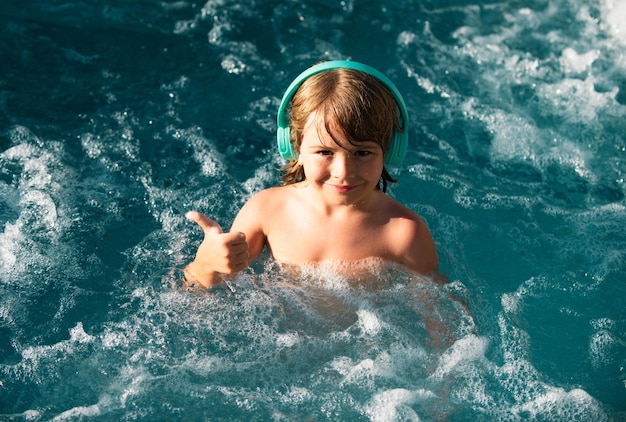 Happy kid playing in outdoor swimming pool on hot summer day kids learn to swim child in water child