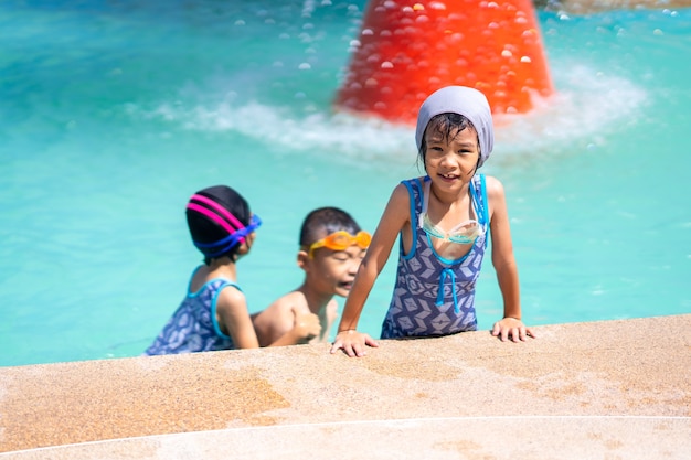 Happy kid playing on swimming pool on daytime