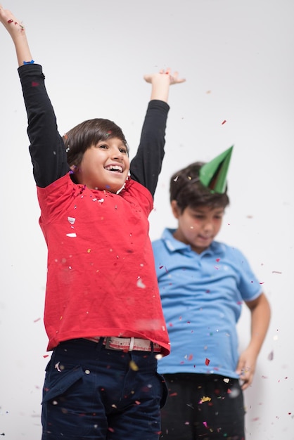 Happy kids celebrating party with blowing confetti