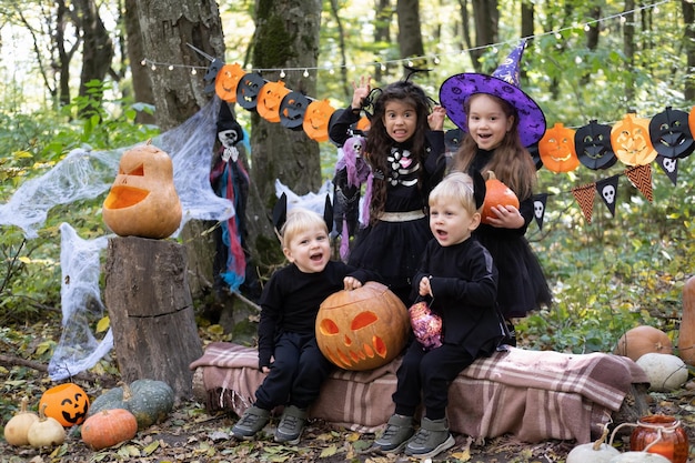 happy kids in halloween costumes having fun in halloween decorations outdoor