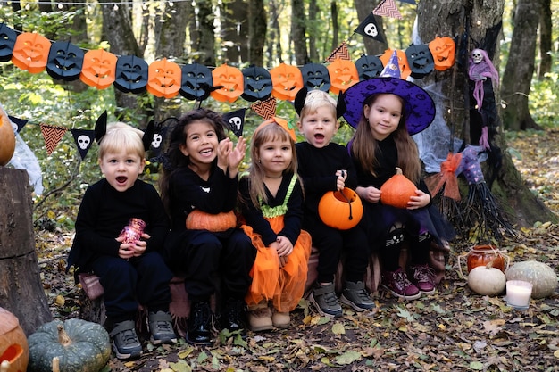 happy kids in halloween costumes having fun in halloween decorations outdoor