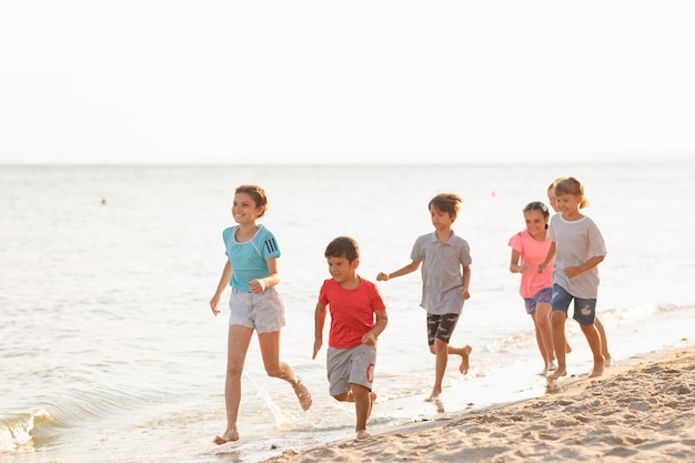 Happy kids running on the beach Cheerful children having good time at summer holidays