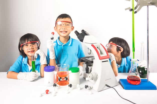 Happy kids in science laboratory on gray background