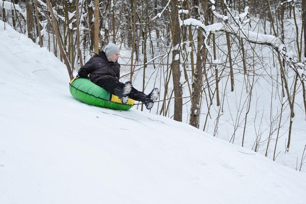 Happy kids tubing down the snow slide in winter. cheerful childrens active sports winter recreation. ice mountain skiing