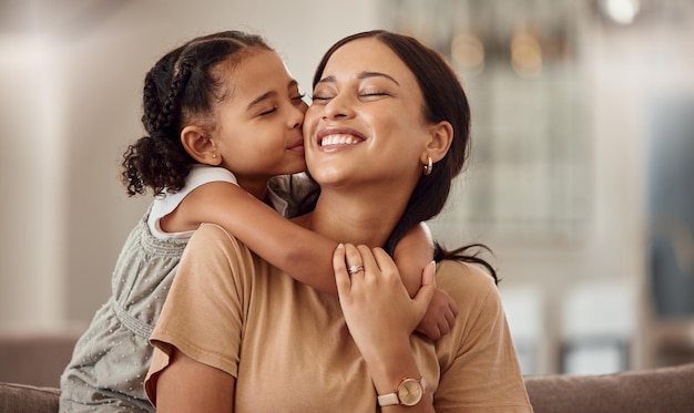 Happy kiss and hug on mothers day in living room sofa love and relaxing together in Australia family home Young girl smile parent and happiness quality time and care on lounge couch for fun