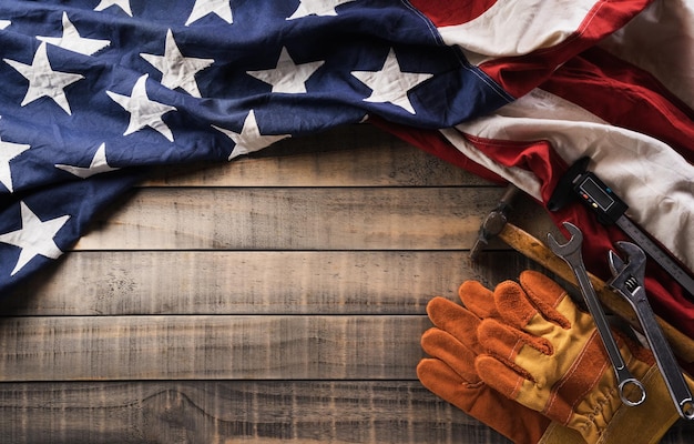 Happy Labor day concept American flag with different construction tools on dark wooden background