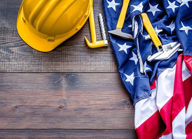 Happy Labor day concept American flag with different construction tools on wooden background