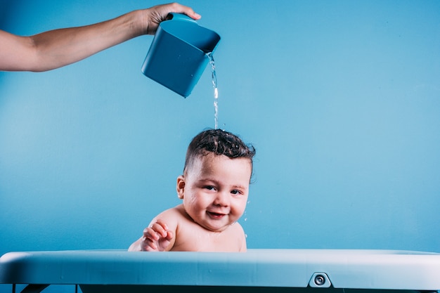 Happy laughing baby taking a bath Smiling kid in bathroom