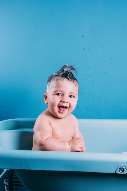 Happy laughing baby taking a bath Smiling kid in bathroom