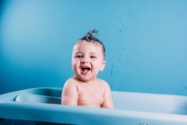 Happy laughing baby taking a bath Smiling kid in bathroom