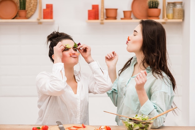 Happy lesbian couple preparing food in kitchen