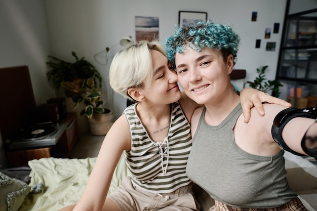 Photo happy lesbian girl making selfie portrait with her girlfriend in the room