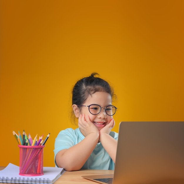 A Happy little asian girl studying online learning class with online video call zoom teacher at home. E-learning or Home schooling education concept. New normal.Covid-19 coronavirus.Social distancing.