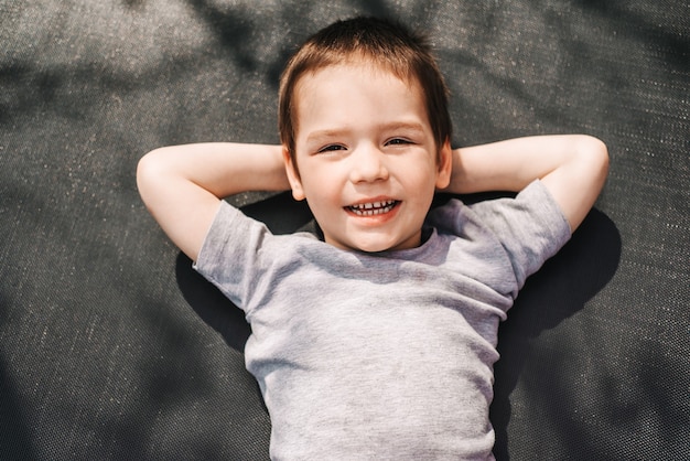 Happy little boy resting outdoors top view