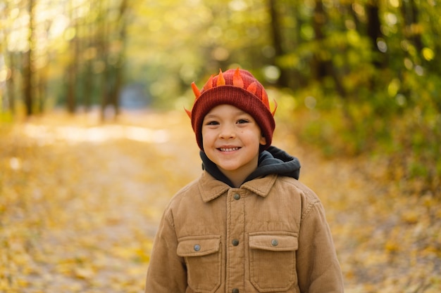 Happy little child baby boy laughing and playing in the autumn day child play with leaves