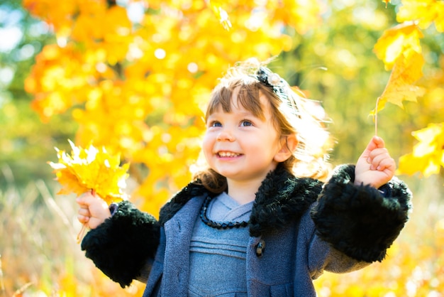 Happy little child, baby girl laughing and playing in the autumn on the nature walk outdoors.